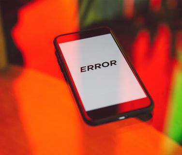 Smartphone-Display mit dem Text ERROR vor buntem Hintergrund, Fehleranzeige.