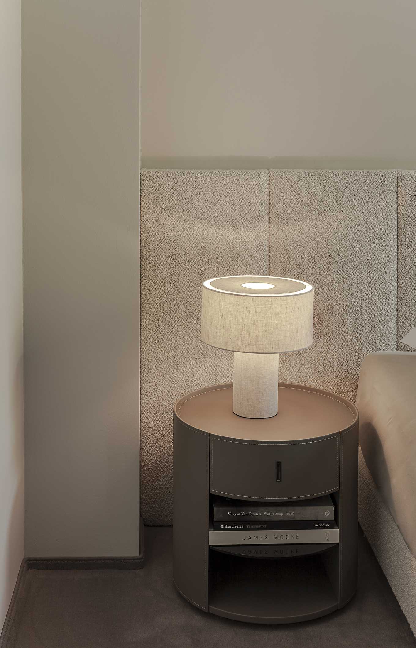 Loft G München: Schlafzimmer mit gepolstertem Betthaupt und Teppichboden Detail Lampe