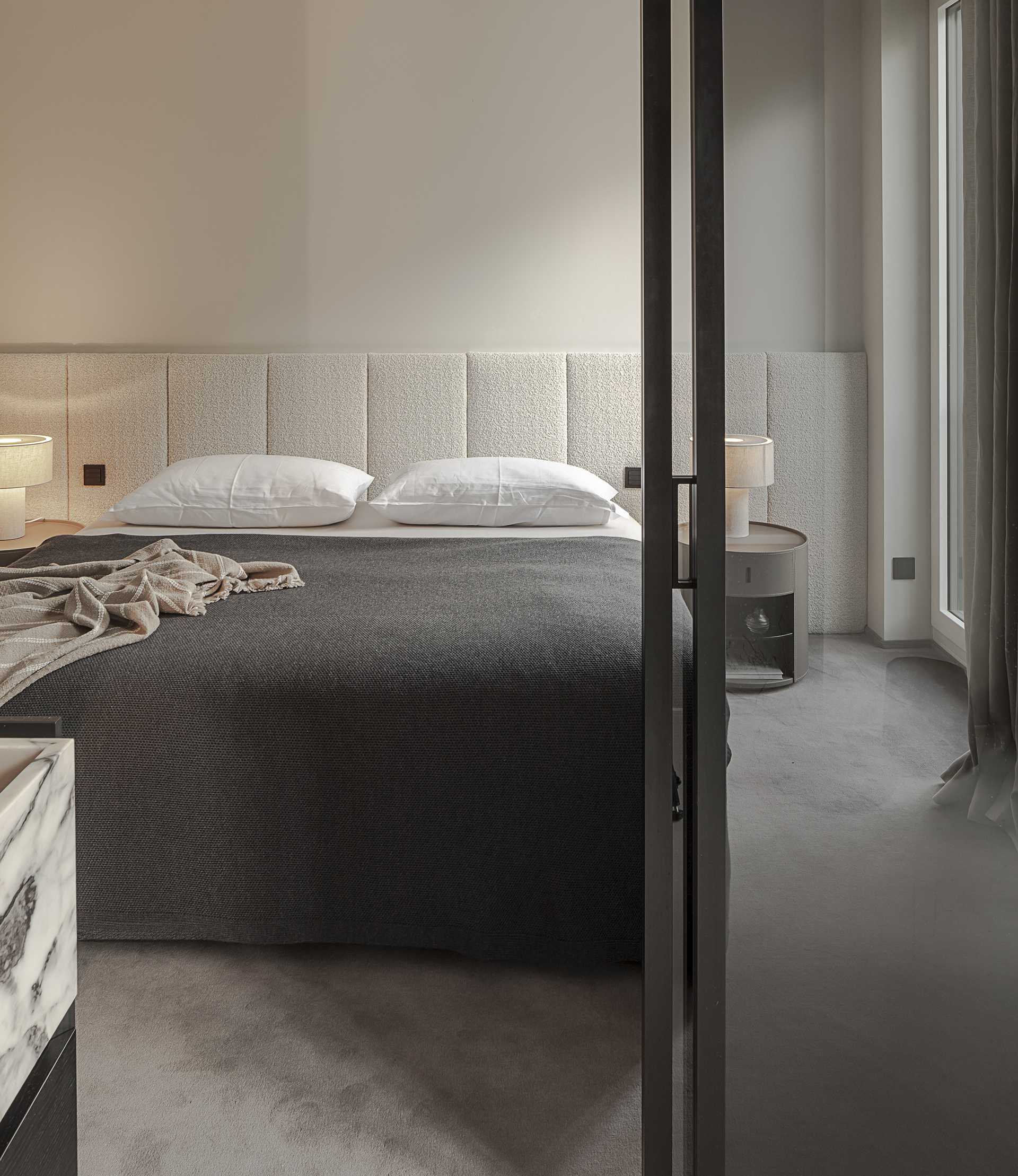 Loft G München: Schlafzimmer mit gepolstertem Betthaupt und Teppichboden Frontal