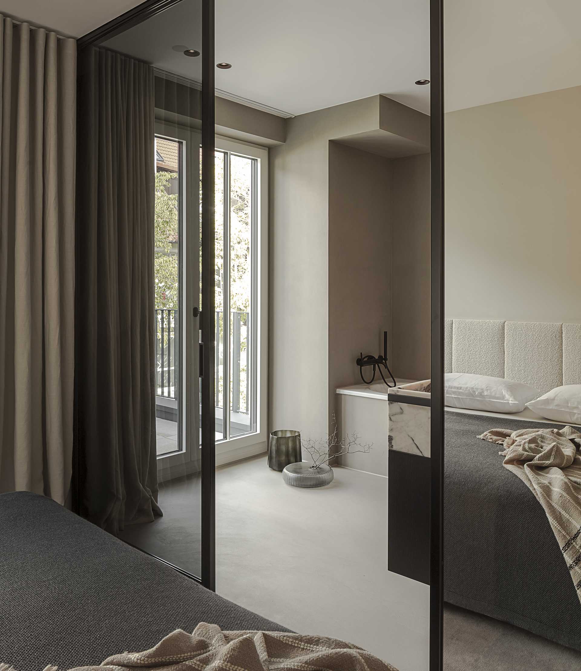 Loft G München: Schlafzimmer mit gepolstertem Betthaupt und Teppichboden Ansicht Bad