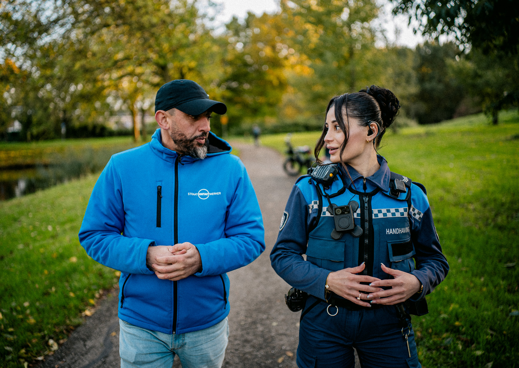 Jeugdboa en Jongerenwerker wandelend in gesprek in een parkje