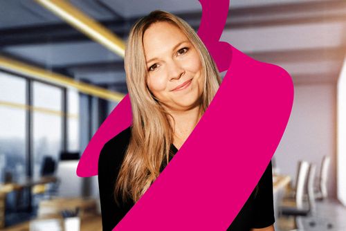 Smiling woman with long hair in an office setting, overlaid with a bold magenta abstract shape.