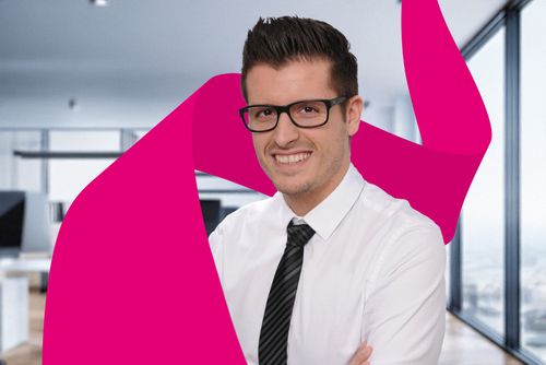 Smiling man in glasses and tie stands in a modern office with pink abstract shapes in the foreground.
