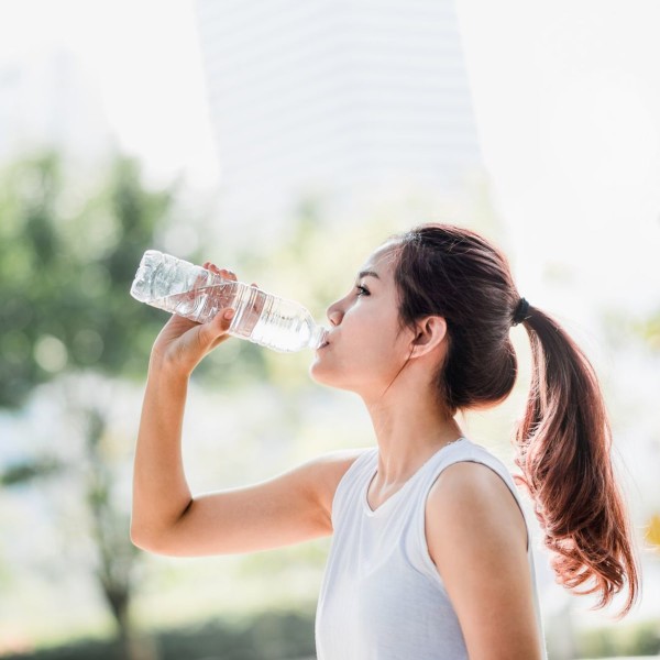 Femme sportive qui s'hydrate en buvant de l'eau à la bouteille