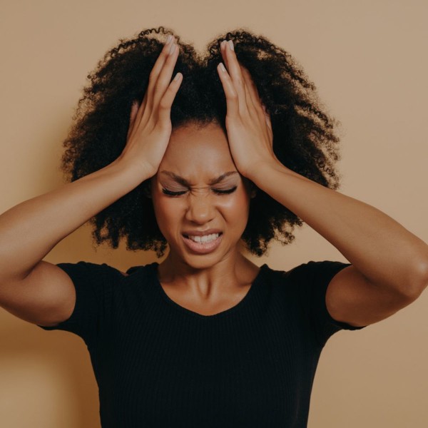 Femme migraineuse qui se tient la tête et grimace