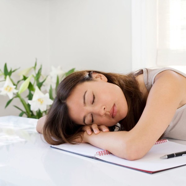 Feune femme fatiguée endormie sur son bureau