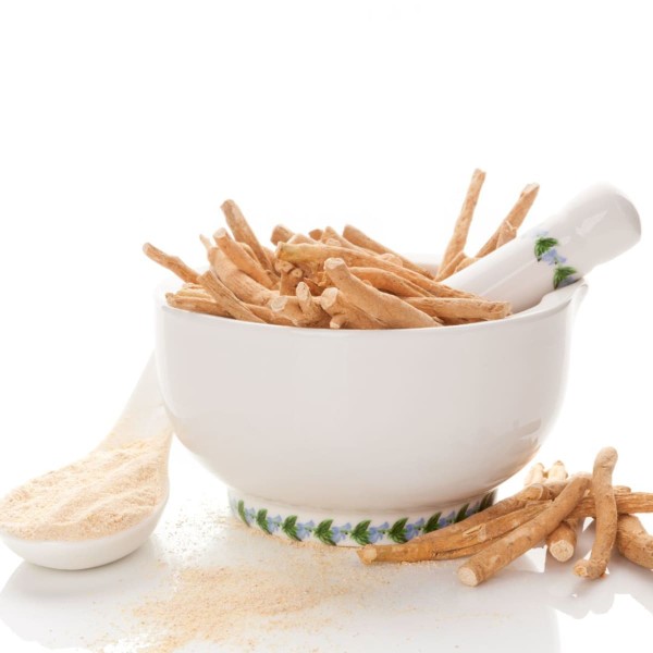 Bol d'ashwaganda en racine et en poudre dans une cuillère, pour préparer un petit-déjeuner anti-inflammatoire