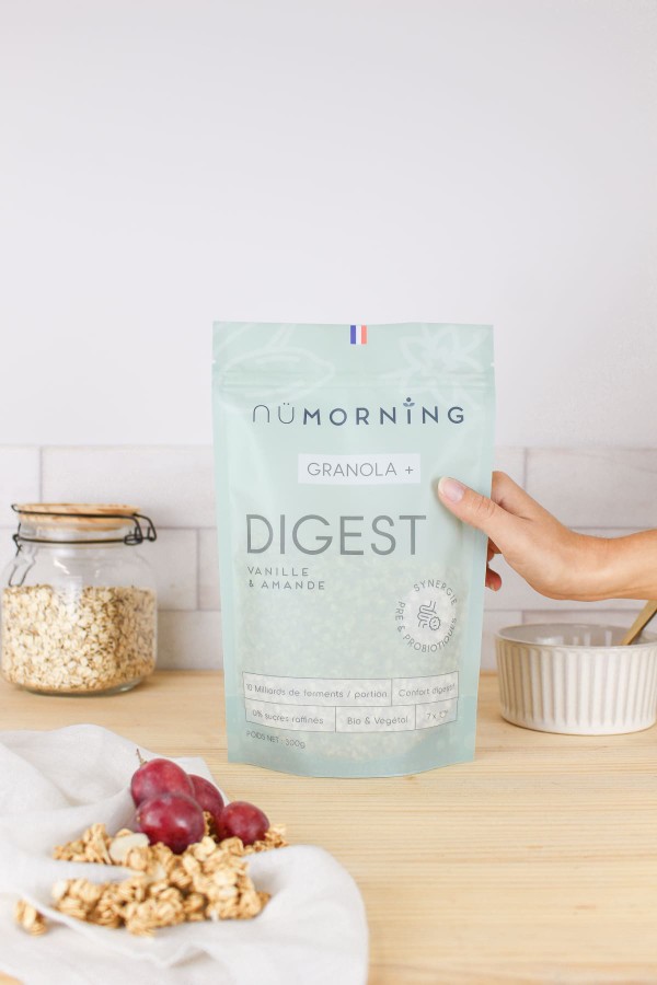 Paquet de granola enrichi en probiotiques pour un petit-déjeuner anti-inflammatoire, à côté d'un bocal de flocons d'avoine et de grains de raisin