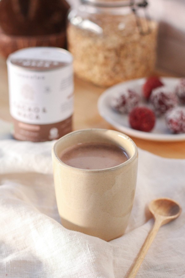 Mug de chocolat chaud sain pour le petit-déjeuner, sur une table avec des fruits et des flocons d'avoine