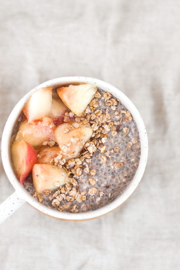 Pudding de chia avec muesli et morceaux de pêche dans un mug