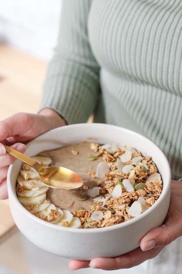 Smoothie bowl facile à digérer pour le petit-déjeuner, avec des tranches de banane et des amanes éfilées