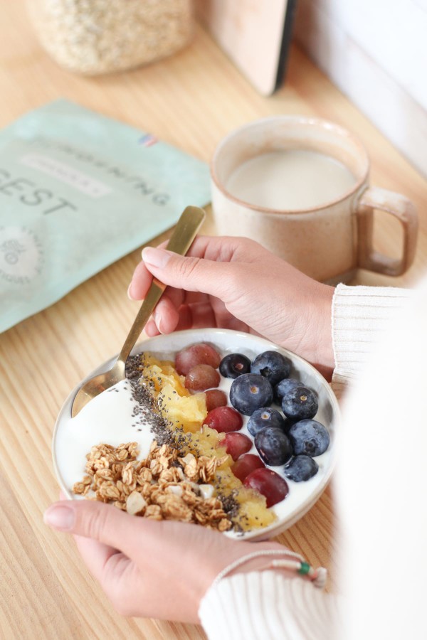 Bol de granola pour le petit-déjeuner facile à digérer, avec des myrtilles, des grains de raisin, de la compote et des graines de chia