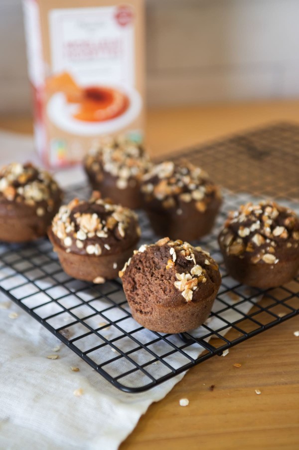 Six muffins à la noisette avec du granola en topping sur une plaque de cuisson, posée sur une table