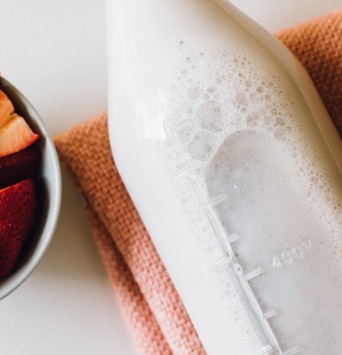 Bouteille de kéfir de lait et fraises coupées en morceaux sur une table