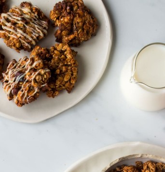 Assiette de cookies au granola sur une table de petit-déjeuner avec un pichet de lait végétal