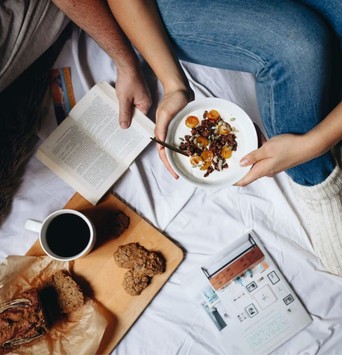 Bol de granola sain et banana bread sur une planche à découper avec un café