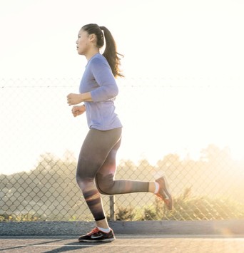 Femme en train de faire de la course à pied en extérieur après son petit-déjeuner