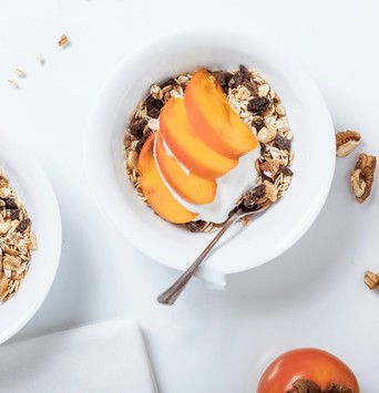 Bol de muesli avec yaourt végétal et fruits frais coupé en tranche pour un petit-déjeuner équilibré