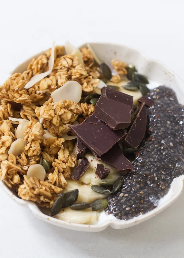 Granola bowl avec base yaourt végétal, graines de chia, chocolat et graines de courge