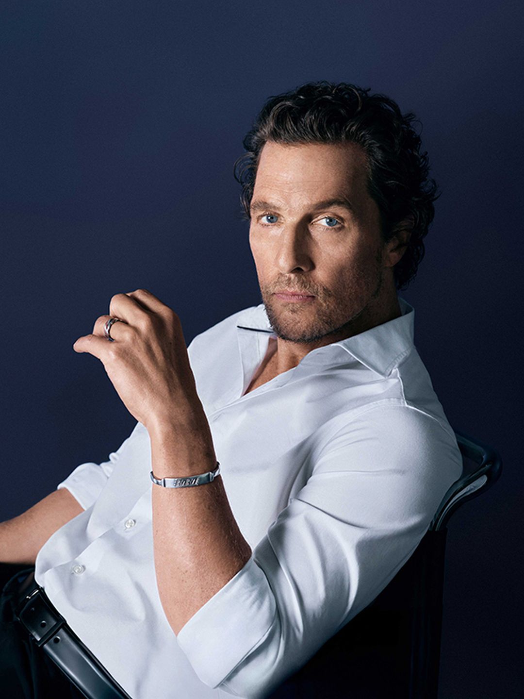 Matthew McConaughey trägt ein weißes OLYMP-Hemd vor dunklem Hintergrund.