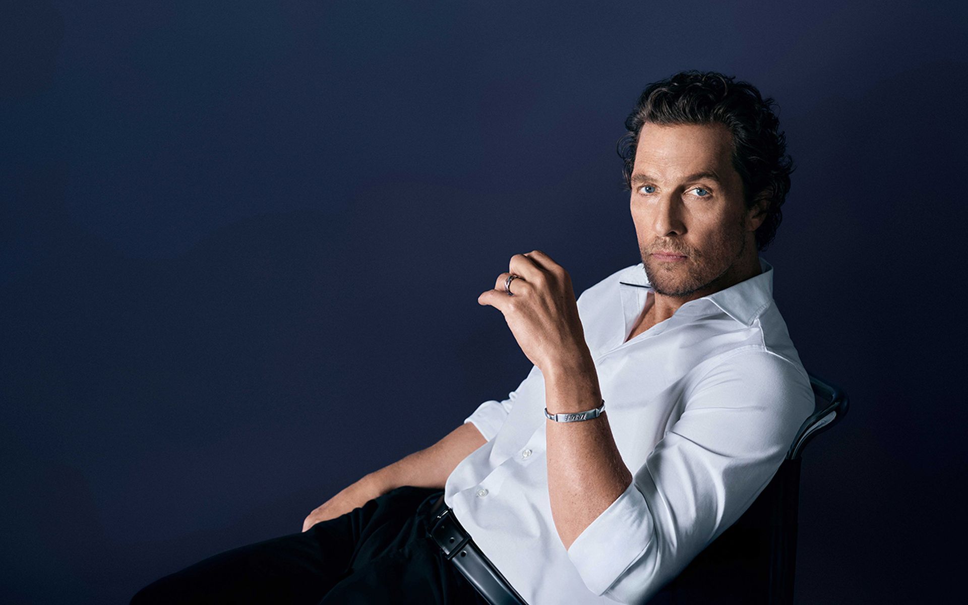 Matthew McConaughey trägt ein weißes OLYMP-Hemd vor dunklem Hintergrund.