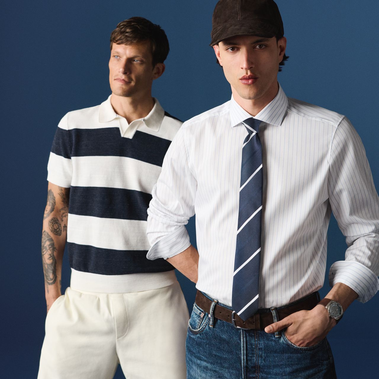 Zwei Models tragen die OLYMP Frühjahr-Sommer Kollektion. Das vordere Model trägt ein helles, fein gestreiftes Businesshemd mit Krawatte. Dahinter steht ein weiteres Model in einem kurzärmeligen Poloshirt mit breiten Streifen in Dunkelblau und Weiß.