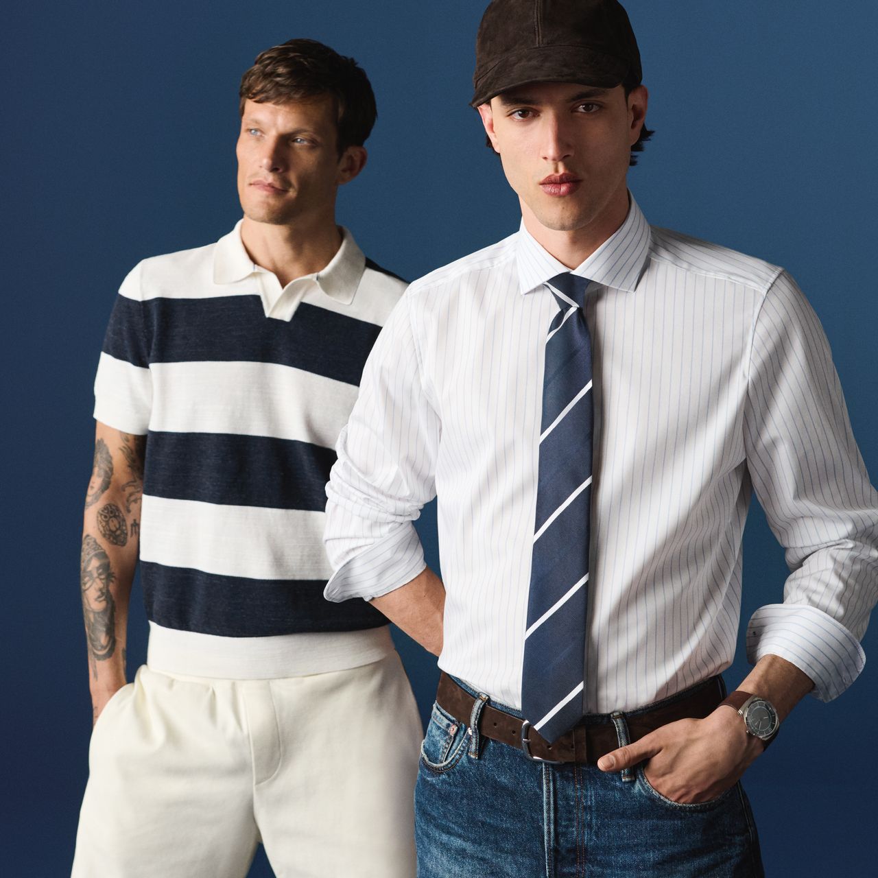 Zwei Models tragen die OLYMP Frühjahr-Sommer Kollektion. Das vordere Model trägt ein helles, fein gestreiftes Businesshemd mit Krawatte. Dahinter steht ein weiteres Model in einem kurzärmeligen Poloshirt mit breiten Streifen in Dunkelblau und Weiß