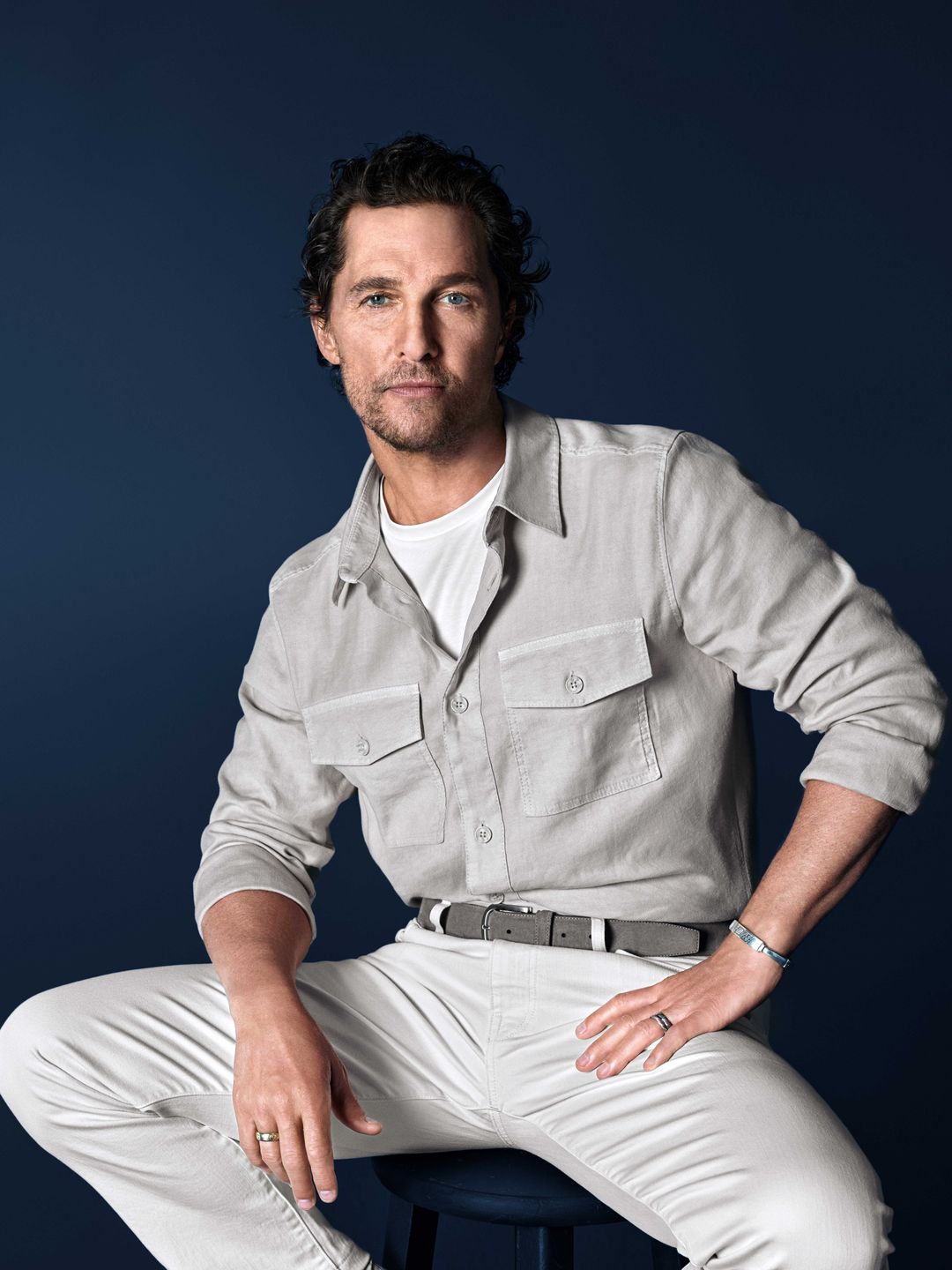 Matthew McConaughey trägt ein beiges OLYMP-Casualhemd vor dunklem Hintergrund.