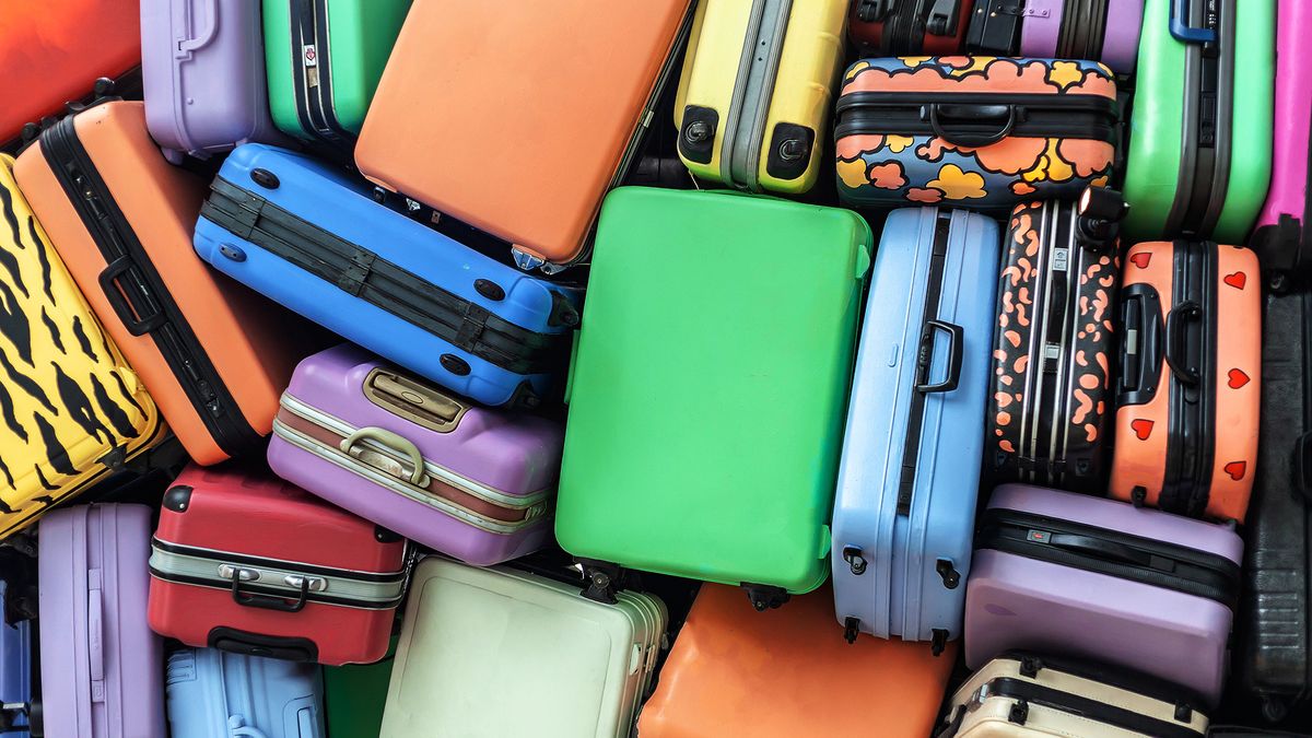 Viele bunte Koffer liegen übereinander und verdeutlichen das Chaos zu Reisebeginn, das mit Messenger-Kommunikation gelindert werden kann.
