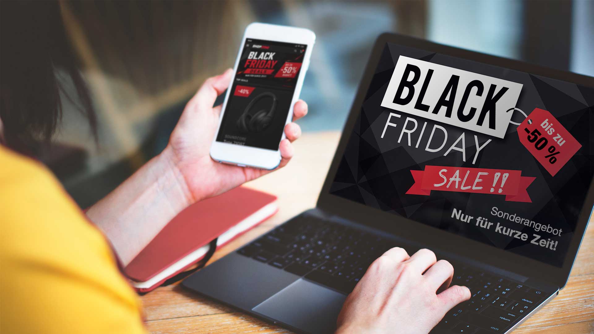 Eine Person, die ein Smartphone und einen Laptop auf dessen Bildschirm ist eine Black-Friday-Werbeanzeige mit bis zu 50 % Rabatt zu sehen.