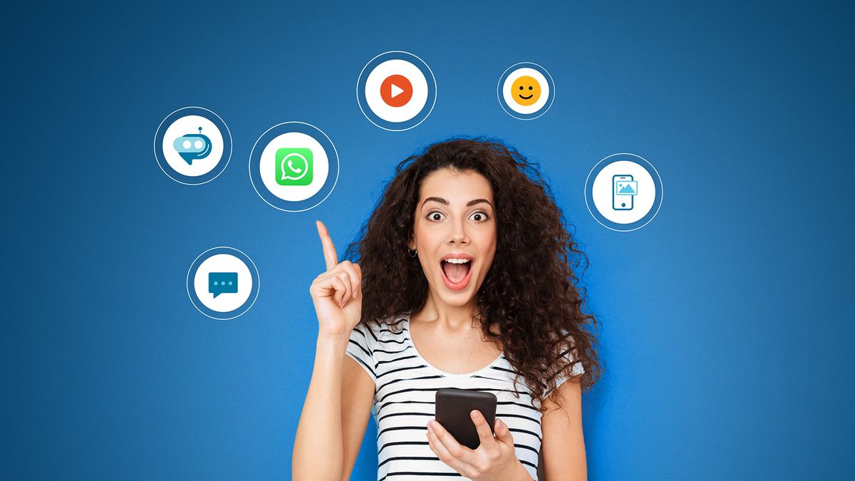Eine Frau, die ein Handy in der Hand hält und aufgeregt auf digitale Symbole zeigt, die Chat, Video und Emoticons auf blauem Hintergrund darstellen.