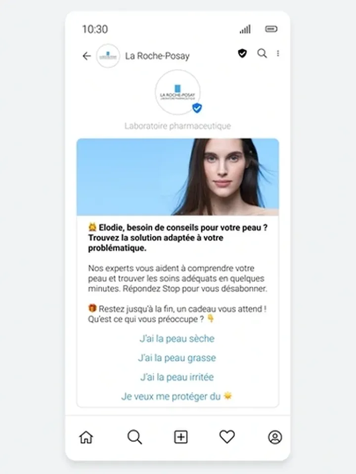 En smartphoneskärm som visar en RCS Business Messaging-konversation från La Roche-Posay. Meddelandet innehåller en logotyp med ett verifierat avsändarmärke, ett foto av en kvinna med klar hud och personlig text som adresserar "Élodie". Meddelandet erbjuder hudvårdsråd med interaktiva alternativ för att välja hudproblem: "Jag har torr hud", "Jag har fet hud", "Jag har irriterad hud" och "Jag vill skydda mig mot solen." Den rika medialayouten och klickbara knapparna förbättrar användarens engagemang jämfört med traditionella SMS.