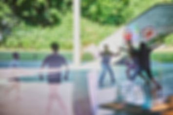 Mehrere Jugendliche spielen draußen gemeinsam Basketball.