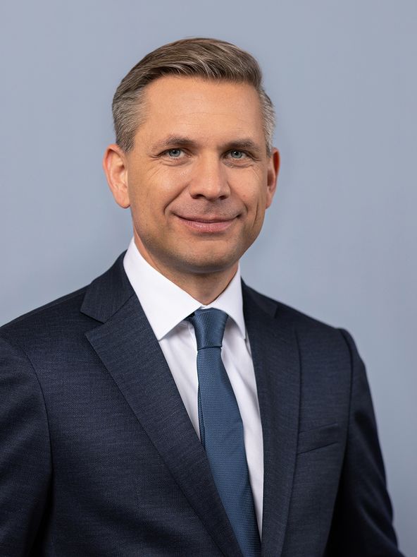 Wolfgang Hattmannsdorfer im Anzug vor grauem Hintergrund