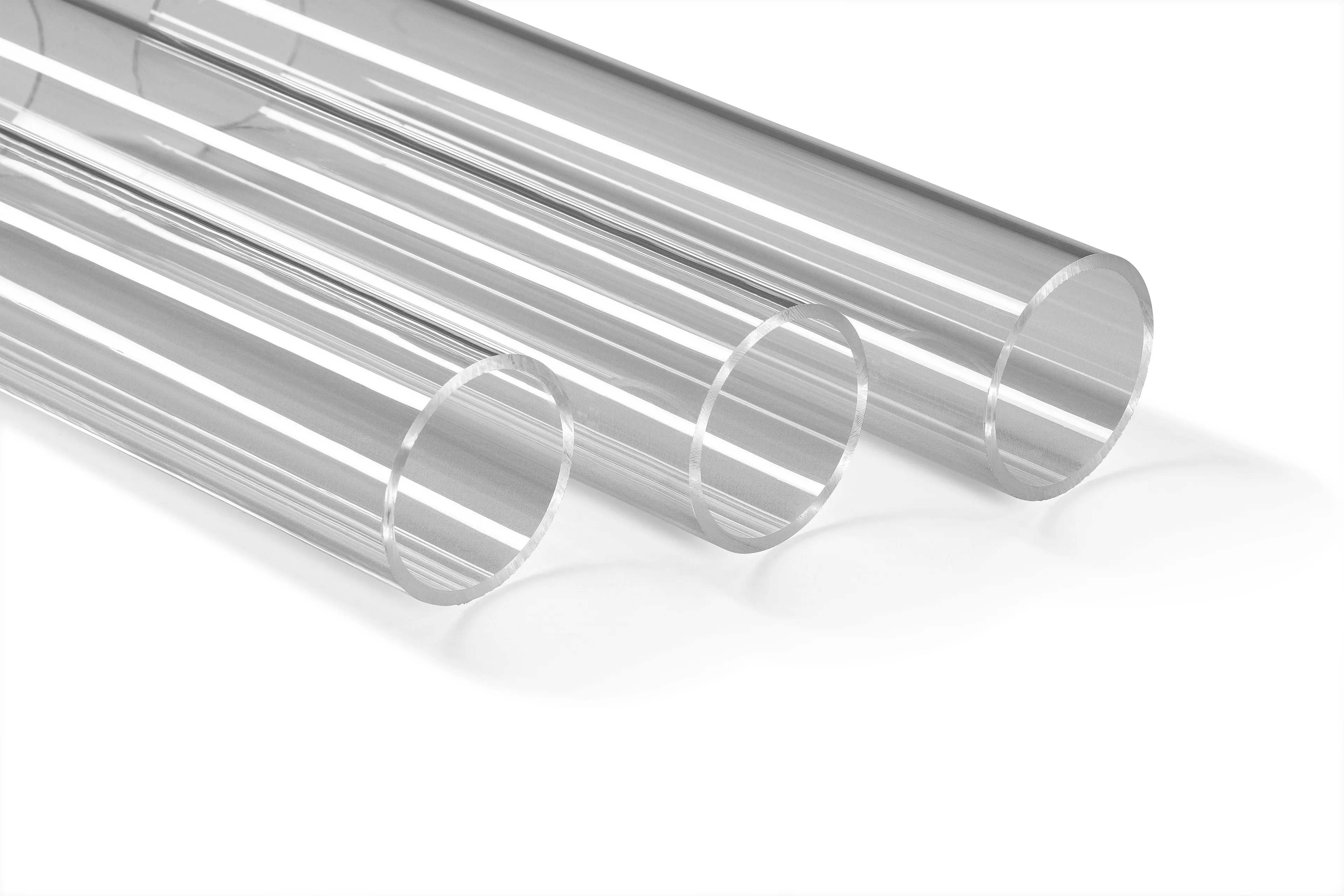 Three clear, cylindrical glass tubes of varying diameters are aligned diagonally on a white background.