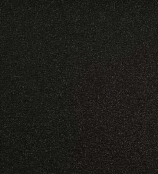 Close-up of a dark grey textured surface, possibly fabric or sandpaper, with a slightly rough appearance.