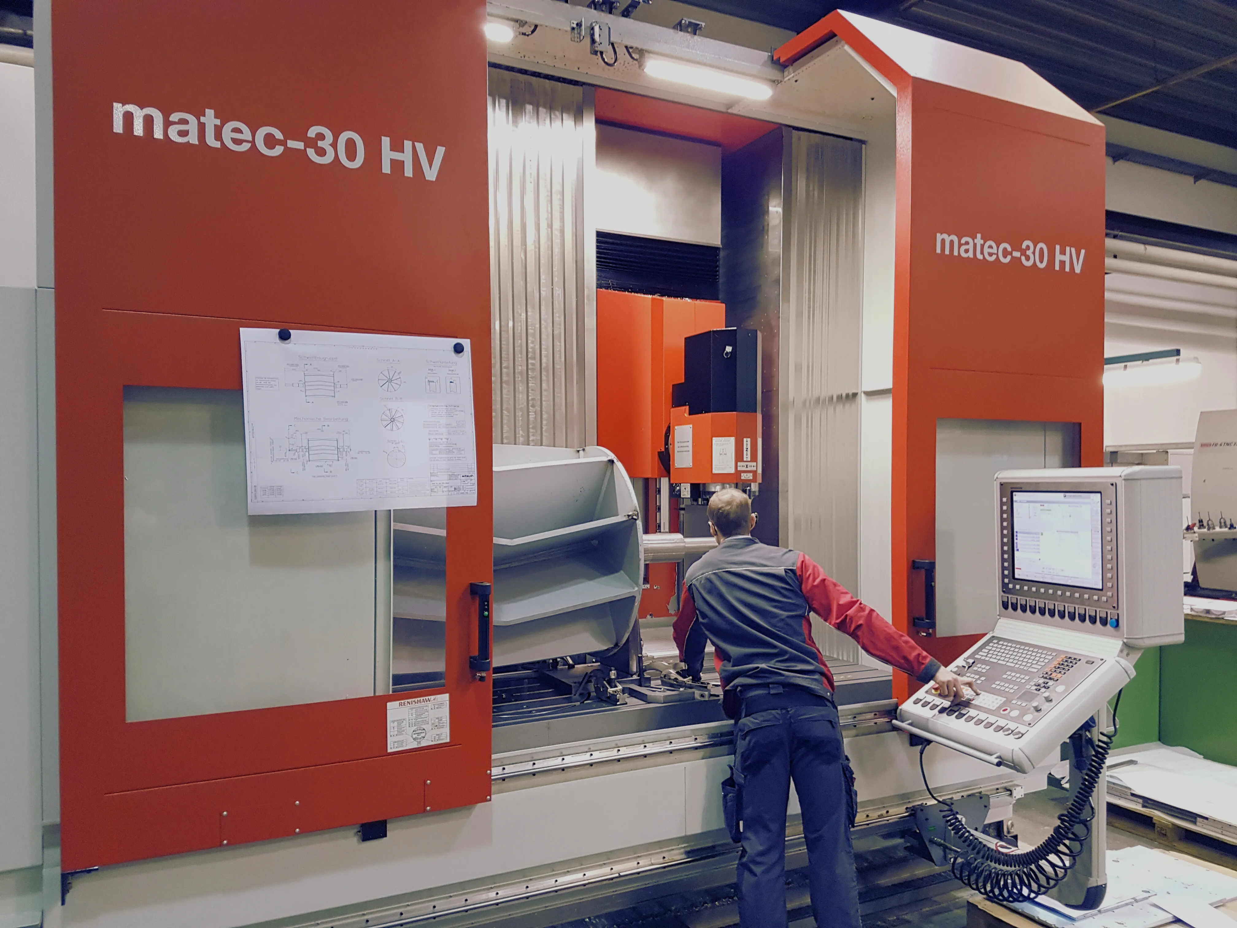 A worker operates a large CNC machine labeled "matec-30 HV" with a control panel and blueprint in an industrial setting.