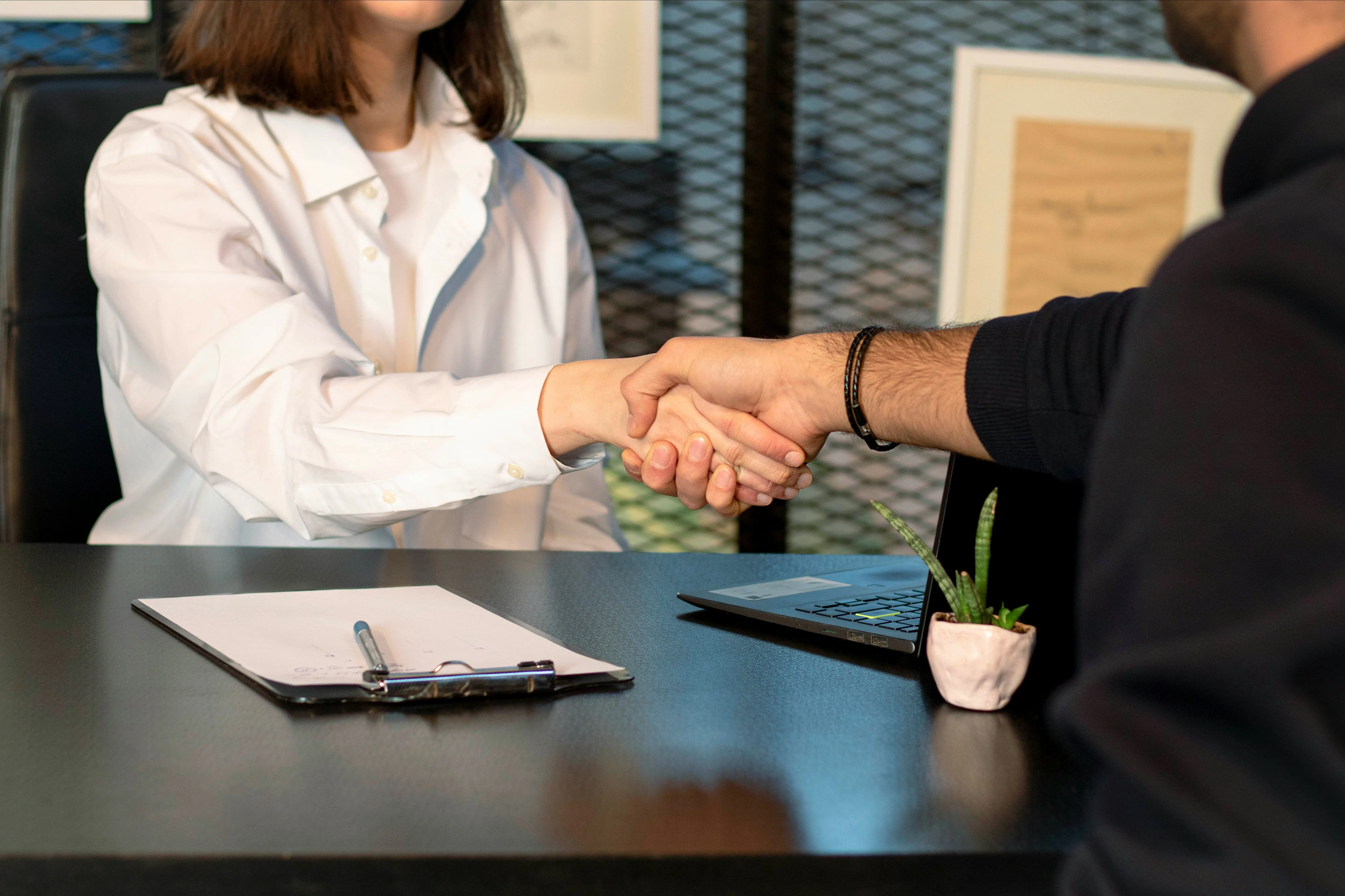 Detailbild von einer weiblichen und einer männlichen Person, die sich die Hand geben