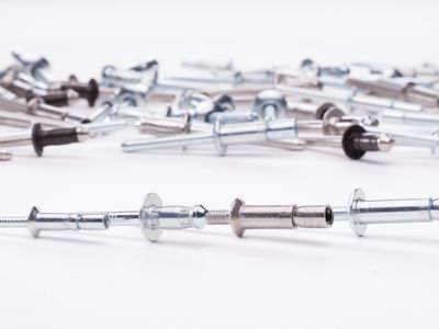 A collection of variously sized custom blind rivets on a white surface