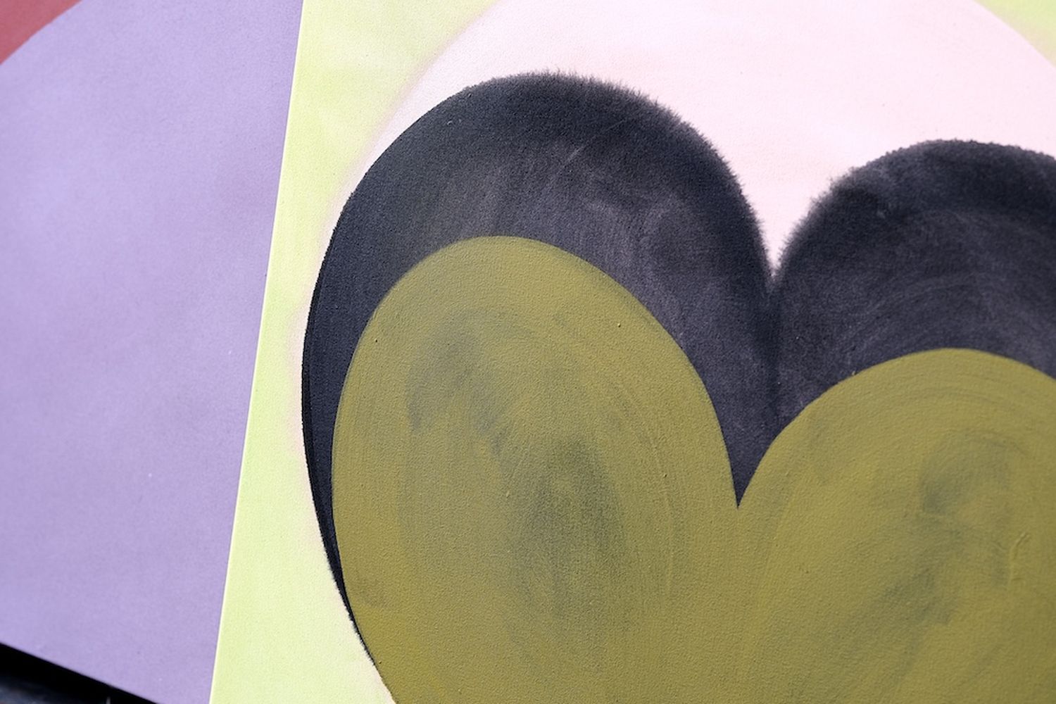 A heart-shaped painting on a canvas, with a green and black heart shape. [G]