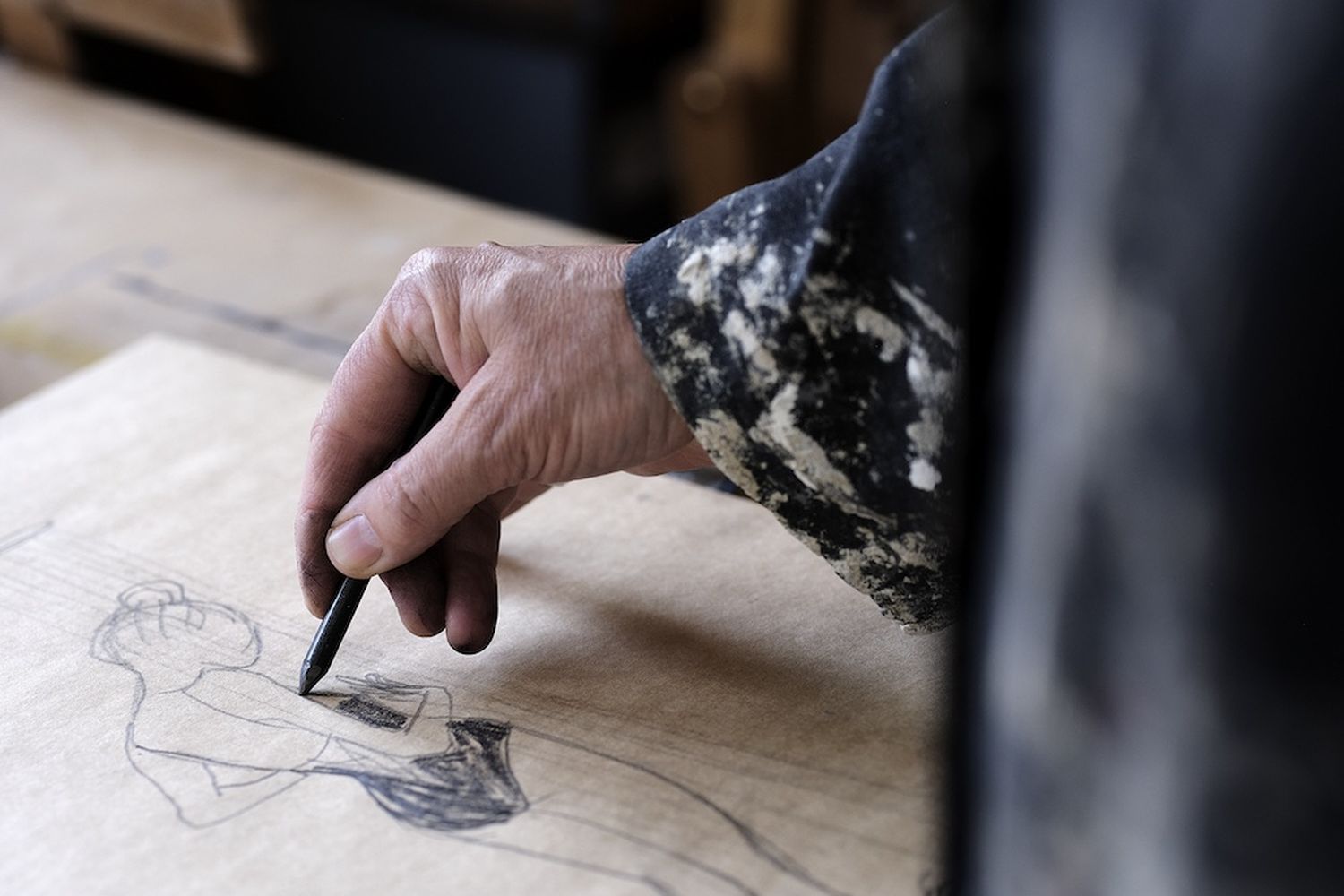 A person is drawing a woman on a piece of paper. [G]