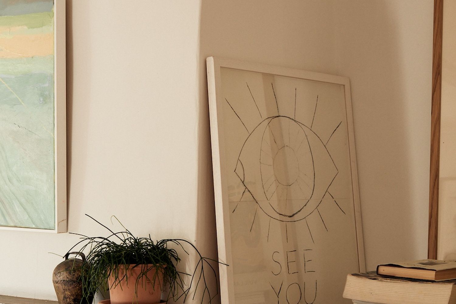 A cozy living room with a fireplace, a potted plant, and a framed artwork. [G]