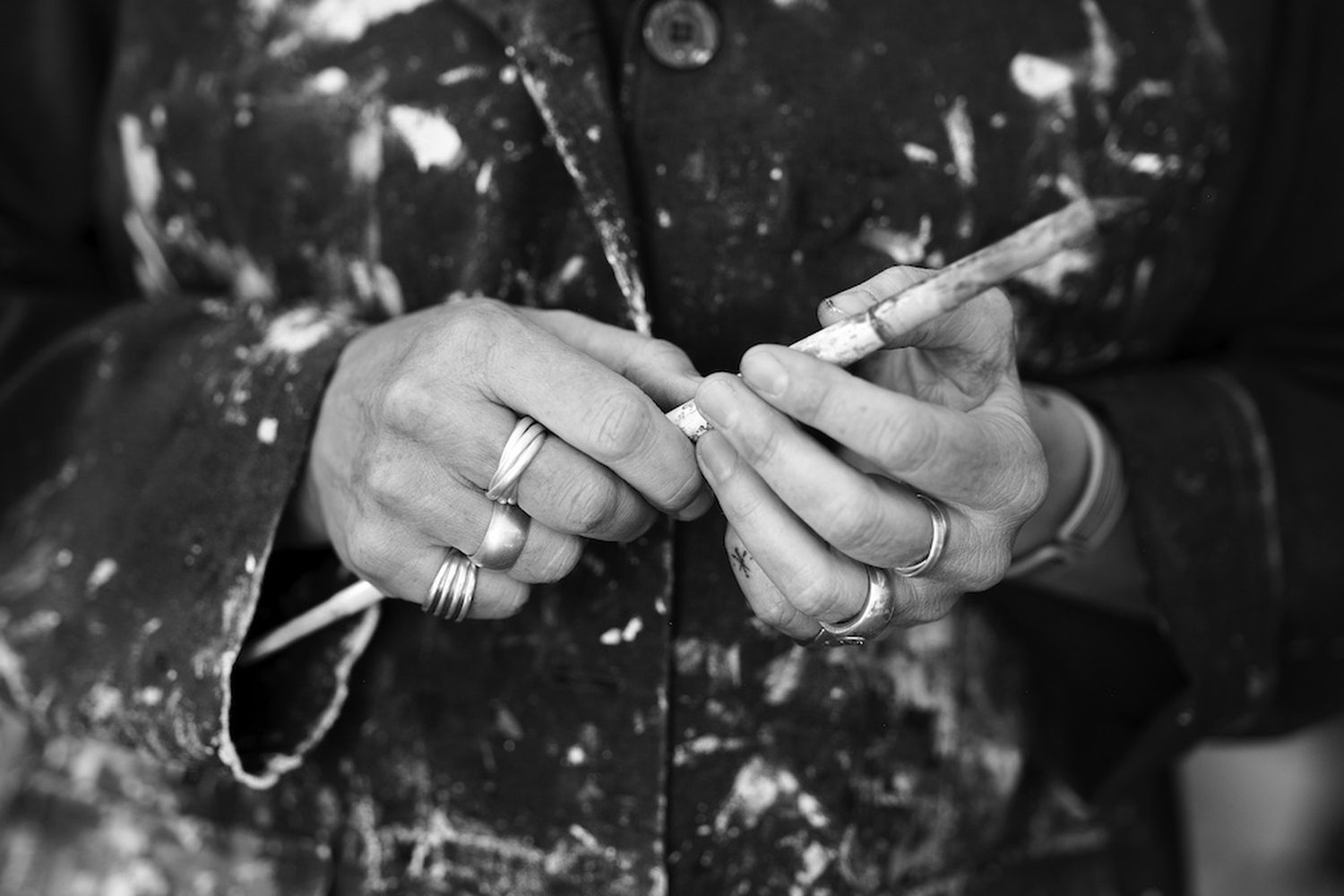 A person is holding a pencil in their left hand and a cigarette in their right hand. [G]