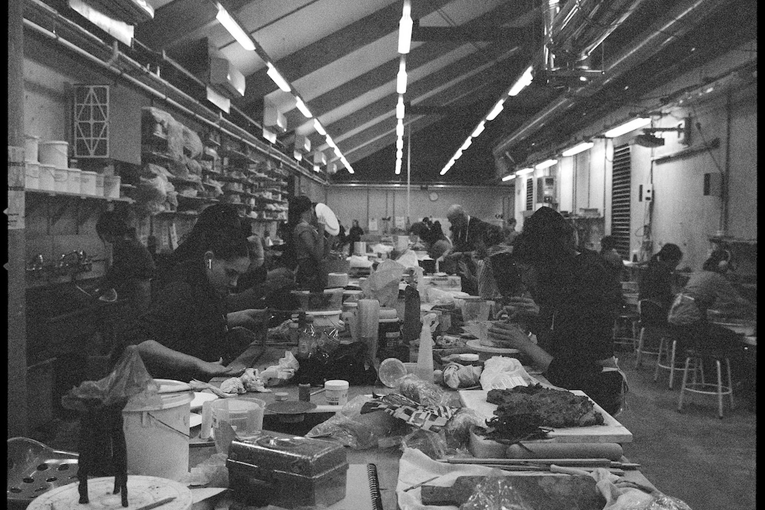 black and white image with male and female artists preparing clay and creating ceramics projects.