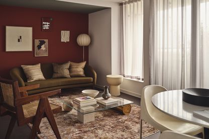 "Stylish living room with burgundy accent wall in Way of Life luxury apartment rentals, featuring modern furniture and natural light." [G]