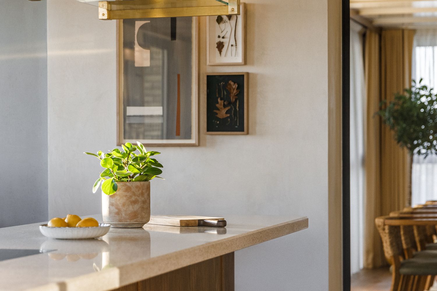 A cozy kitchen with a wooden counter, a potted plant, and a bowl of oranges. [G]