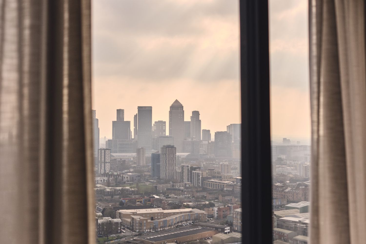 A cityscape with tall buildings and a cloudy sky. [G]
