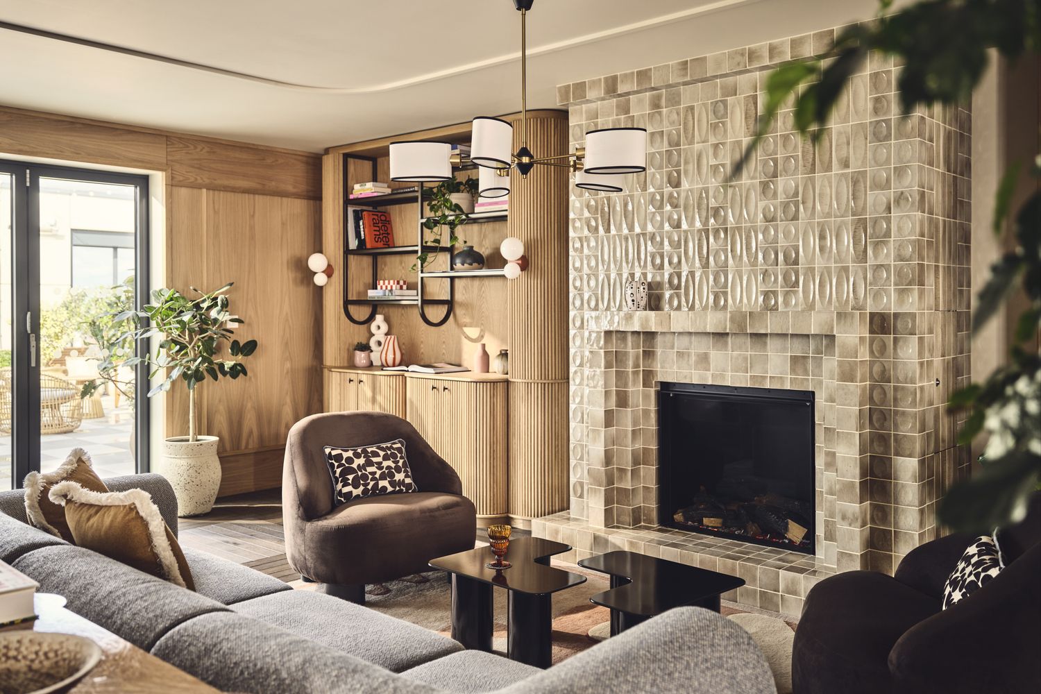 A cozy living room with a fireplace, comfortable seating, and a bookshelf. [G]
