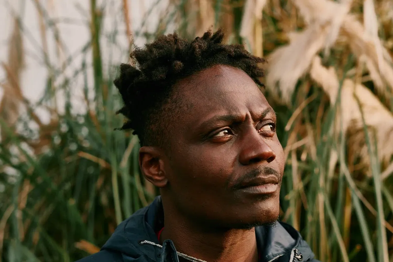 black male in jacket looking off camera