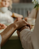 A close up of two people holding hands at a table inside a yellow cut out shape